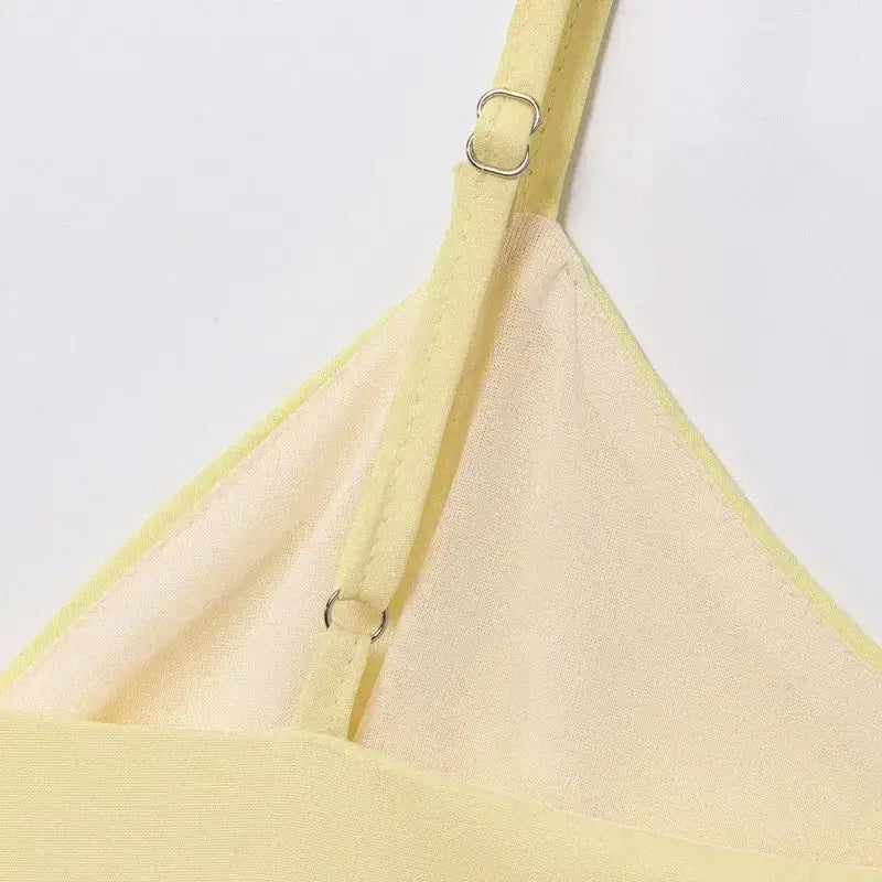 Close-up of adjustable strap detail on yellow puffy sleeveless summer top
