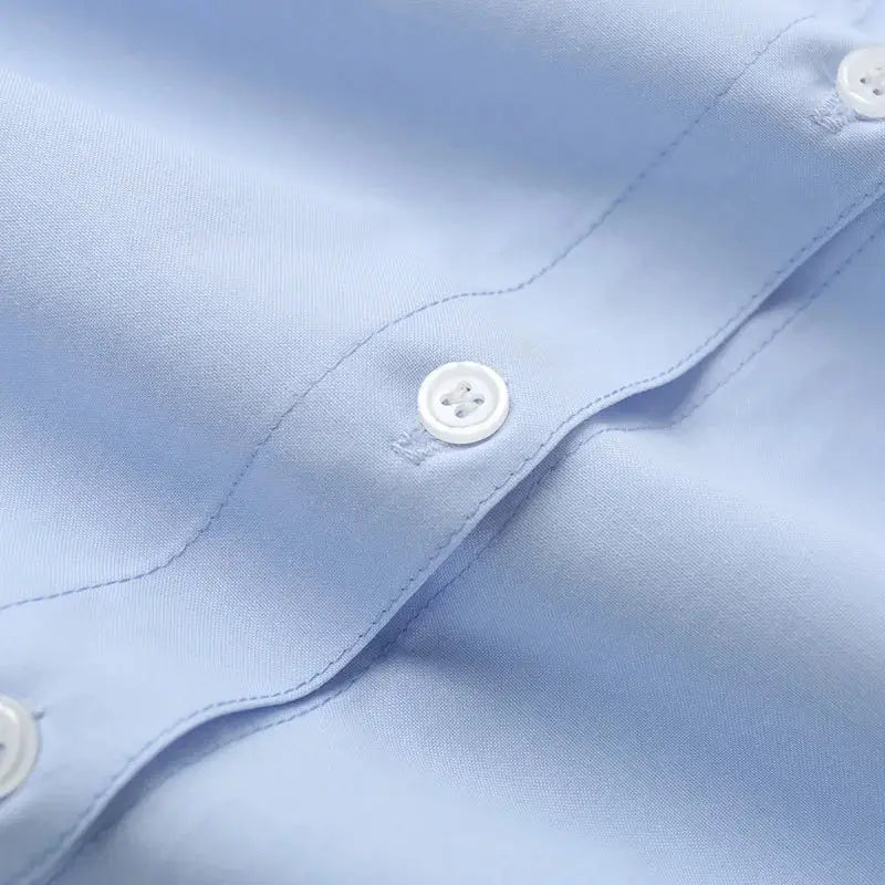 Close-up of light blue spring long sleeve office shirt with white buttons and smooth fabric