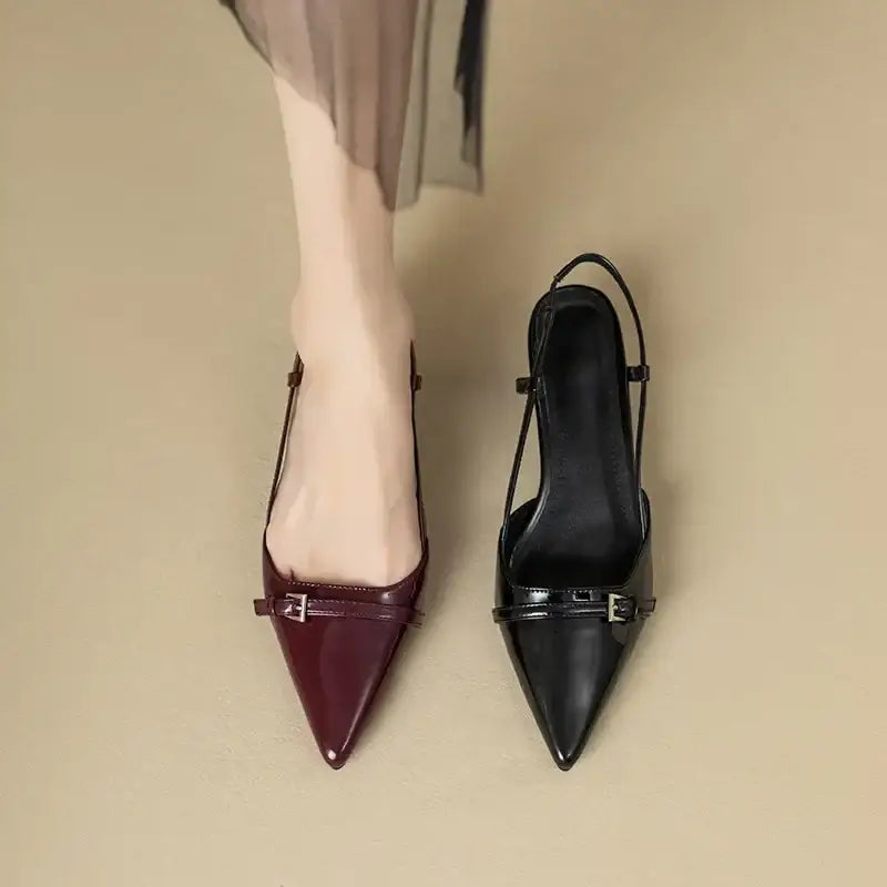 Burgundy and black patent slingback heels with pointed toes and buckle straps.