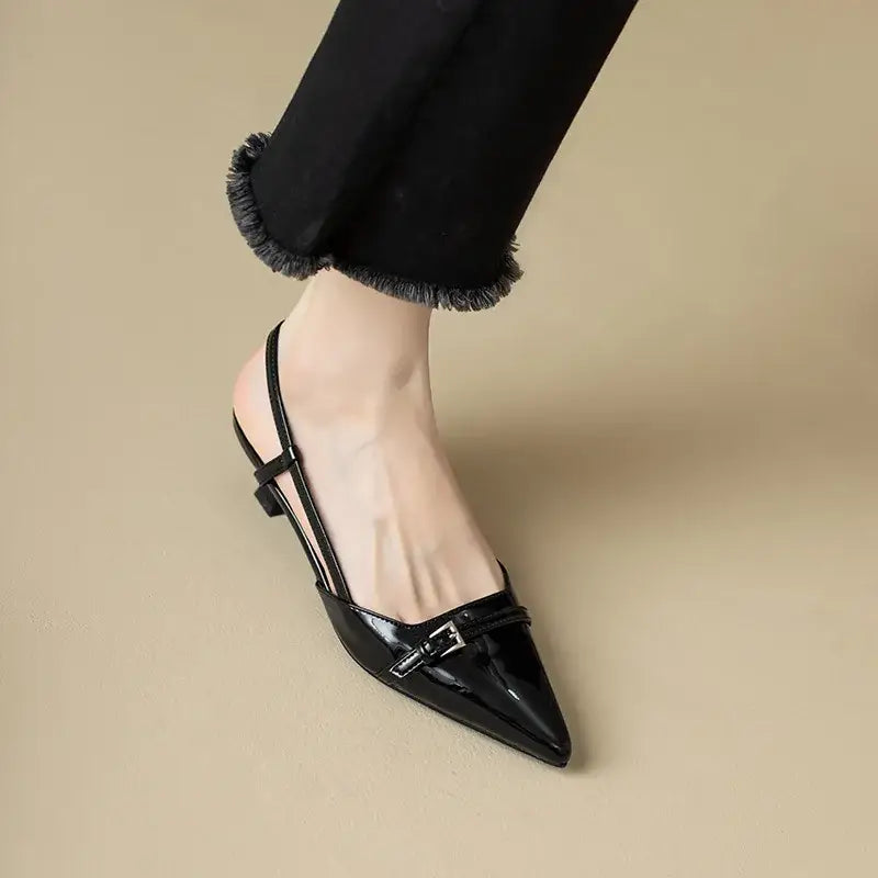 Black patent leather slingback heel with pointed toe and buckle detail.
