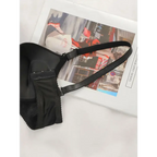Black lingerie with adjustable shoulder strap lying on a magazine page display