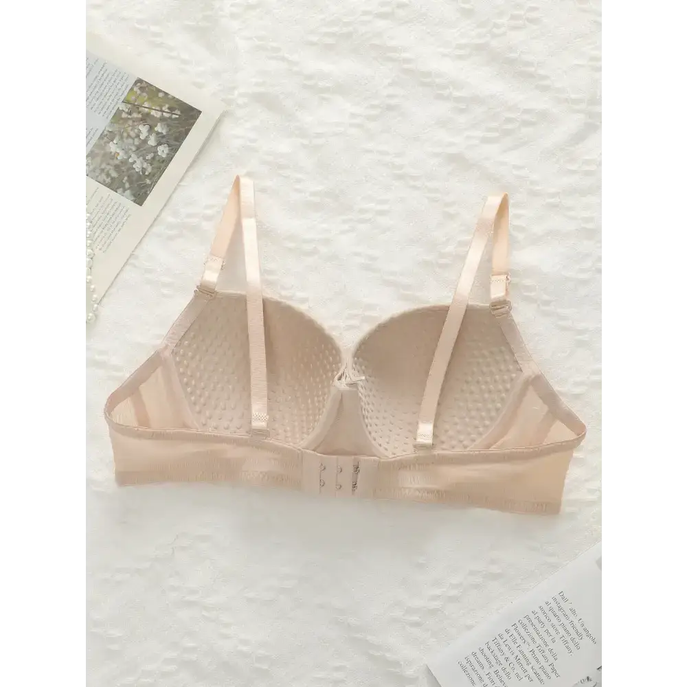 Beige adjustable shoulder strap lingerie bra from The Lady's Haven Boutique laid flat on white textured surface