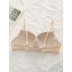 Beige adjustable shoulder strap lingerie bra from The Lady's Haven Boutique laid flat on white textured surface