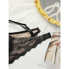 Black adjustable strap lace bra for women with intricate floral lace design laid beside a gold ornate mirror and pearl necklace
