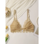 Beige lace adjustable strap wireless bra from The Lady's Haven Boutique laid flat with decorative flowers and accessories