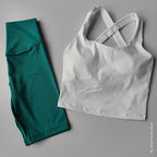 2 piece workout outfit featuring a white crossed-back top and teal leggings for active wear