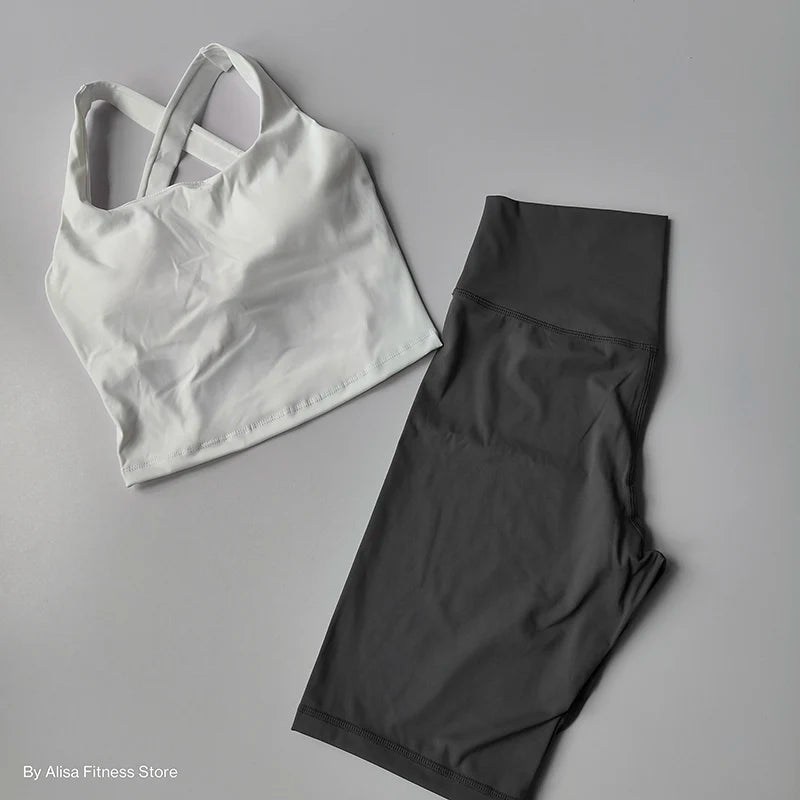 Stylish 2 piece workout outfit featuring a white crop top and black high-waisted leggings