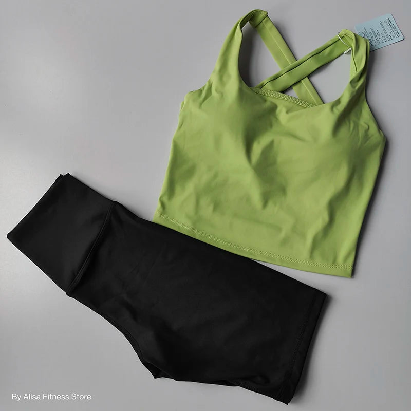 Ladies sports bra and shorts set featuring a green bra and black shorts for activewear style