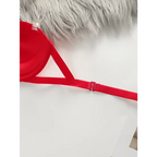 Red anti slip push up bra strap and side detail on white surface with faux fur background