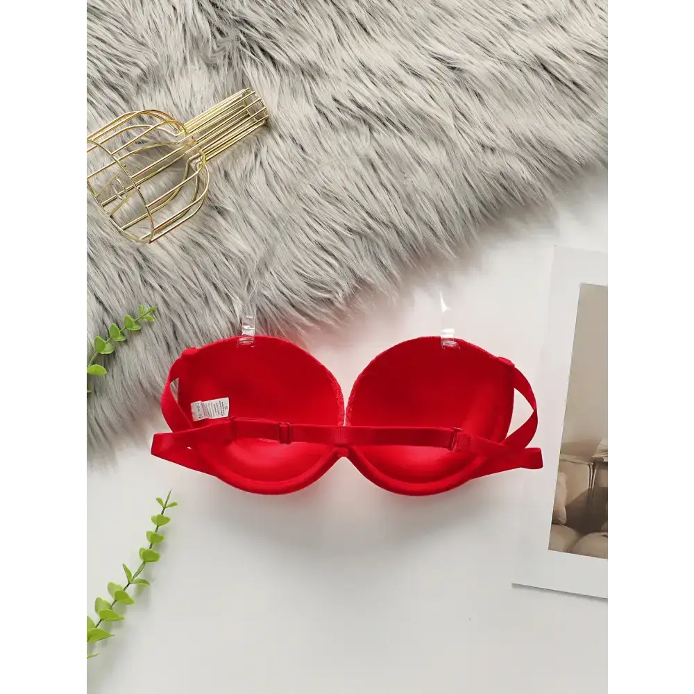 Red anti slip push up bra from The Lady's Haven Boutique displayed on white surface with faux fur background