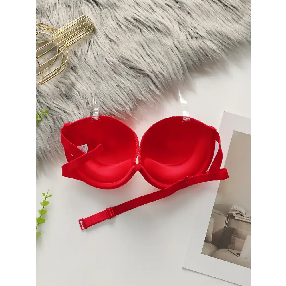 Red anti slip push up bra from The Lady's Haven Boutique displayed on white surface with clear straps
