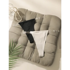 Black and white seamless thong underwear with clear straps displayed on a cushioned chair