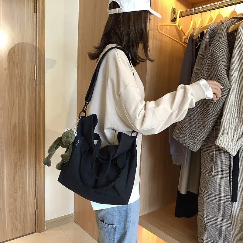 Stylish casual canvas tote bag for women in black being carried by a trendy outfit