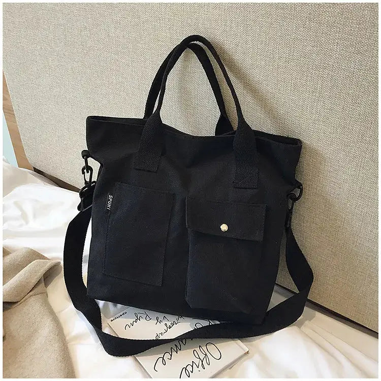 Stylish black casual canvas tote bag for women with two front pockets and a detachable strap