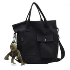 Casual canvas tote bag for women in black with front pockets and a monkey keychain