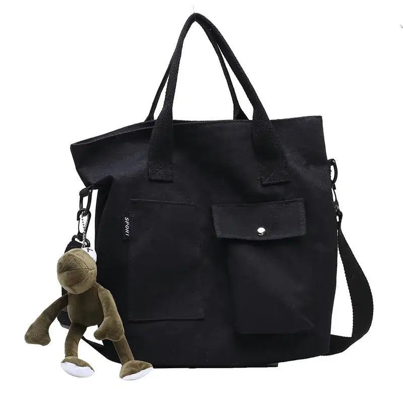 Casual canvas tote bag for women in black with front pockets and a monkey keychain