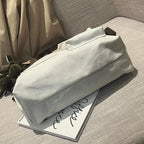 Casual canvas tote bag for women resting on a magazine on a textured surface