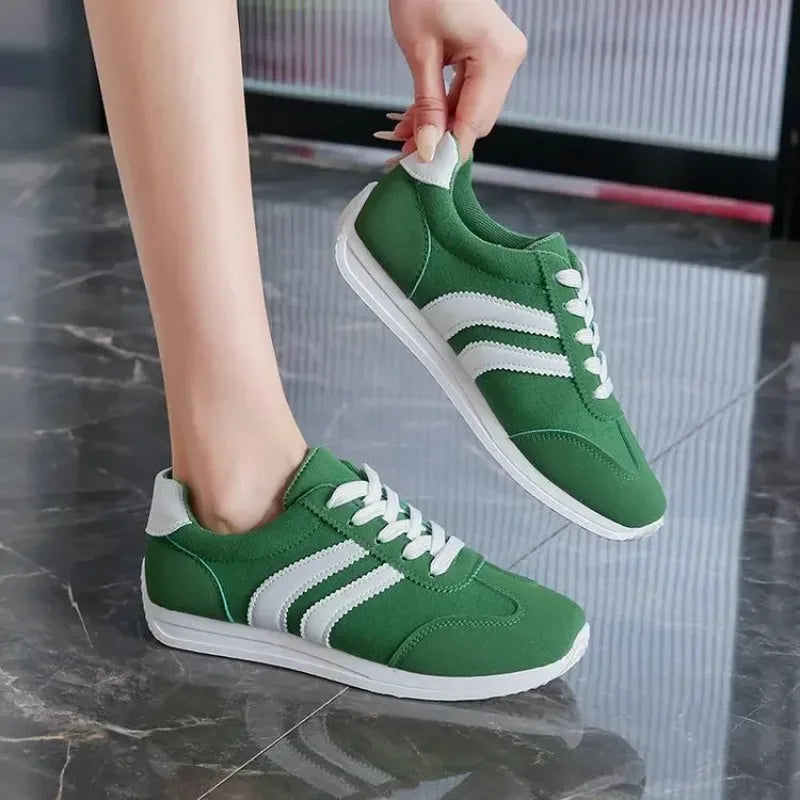 Green casual slip on sneakers with white stripes and laces for comfortable everyday wear