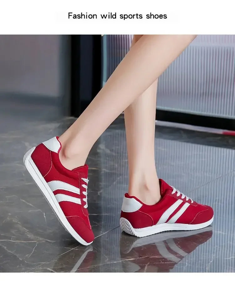 Red casual slip on sneakers with white stripes worn indoors on glossy floor by The Lady's Haven Boutique