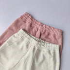 Two pairs of Casual Sports Shorts for Women in pink and cream colors featuring elastic waistbands.