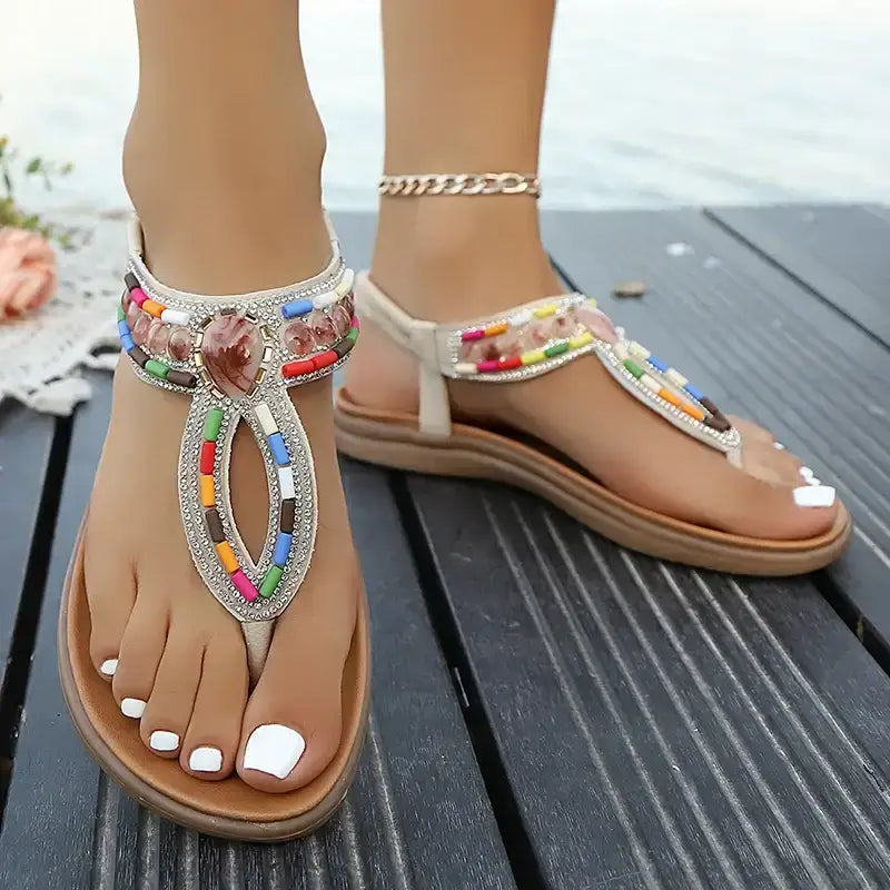 Colorful bohemian beaded sandals flat heel style from The Lady's Haven Boutique on wooden deck