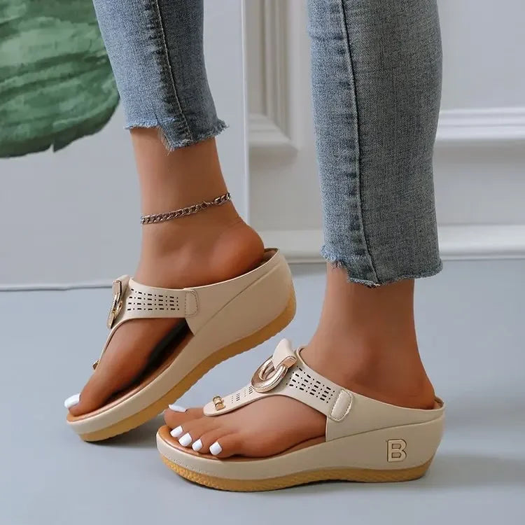 Beige comfortable open toe beach sandals with wedge sole and decorative buckle worn with cropped jeans