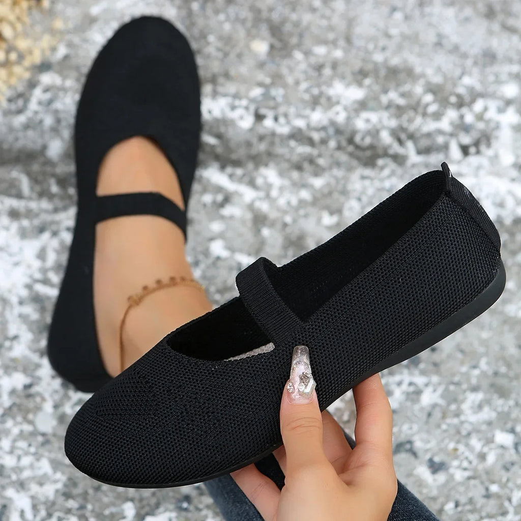 Black comfortable slip-on shoes with a strap and textured fabric material