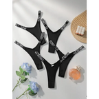 The Lady's Haven Boutique black comfortable thong pack with white logo bands laid out with flowers and perfume