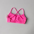 Bright pink cross back sports bra with adjustable straps for comfortable workouts