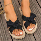 The Lady's Haven Boutique flat heel cross strap comfort sandals with black bow detail and woven sole