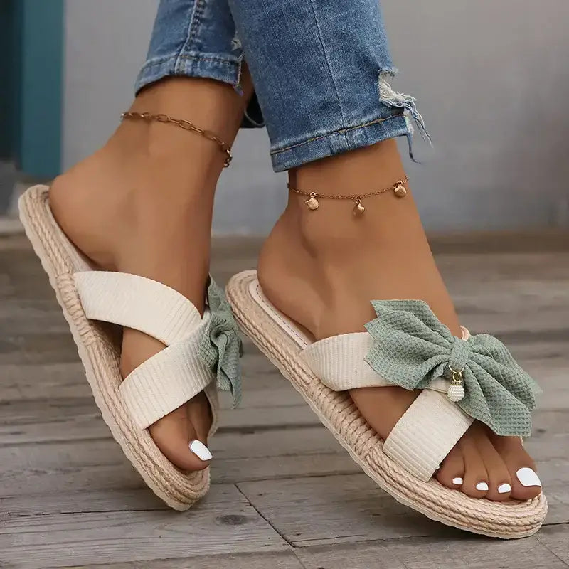 The Lady's Haven Boutique flat heel sandals with cross strap comfort sandals design and decorative green bow