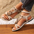 The Lady's Haven Boutique beige cross strap soft sole sandals with floral embellishments on model feet