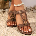 Brown flat heel cross strap soft sole sandals with floral decorations and ankle shell bracelet