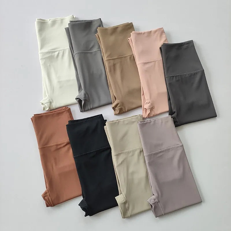 Variety of elastic fitness leggings for women in different colors neatly arranged on a flat surface