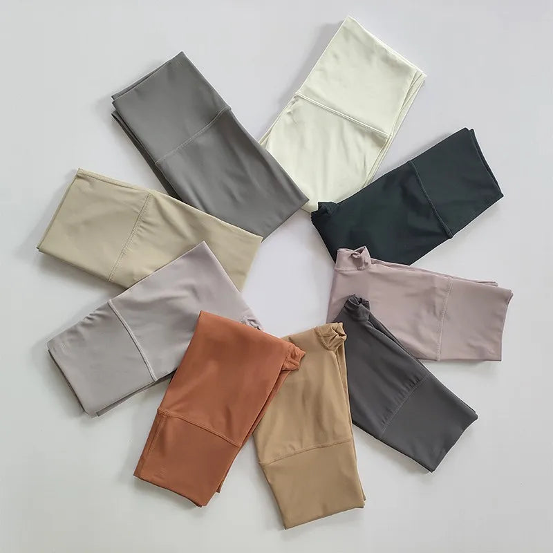 Variety of elastic fitness leggings for women in multiple colors and styles arranged flat