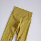 High-waisted elastic fitness leggings for women in mustard yellow color, perfect for workouts and everyday wear