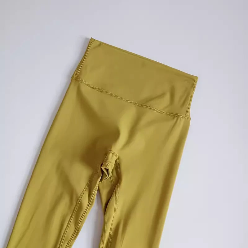High-waisted elastic fitness leggings for women in mustard yellow color, perfect for workouts and everyday wear