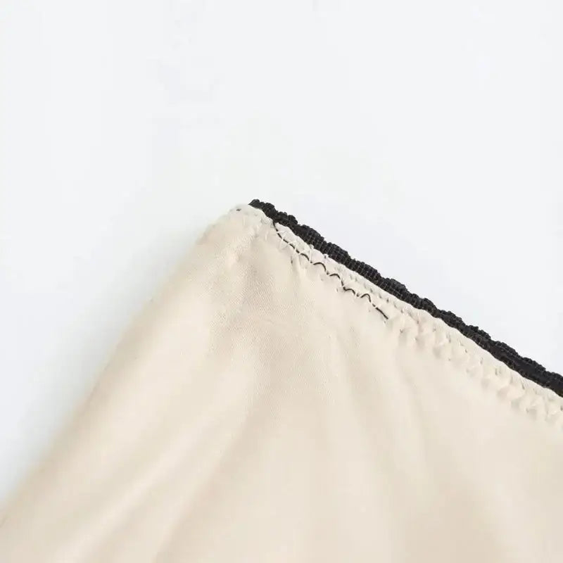 Close-up of cream fabric with black lace trim on a ladies evening skirt from The Lady's Haven Boutique
