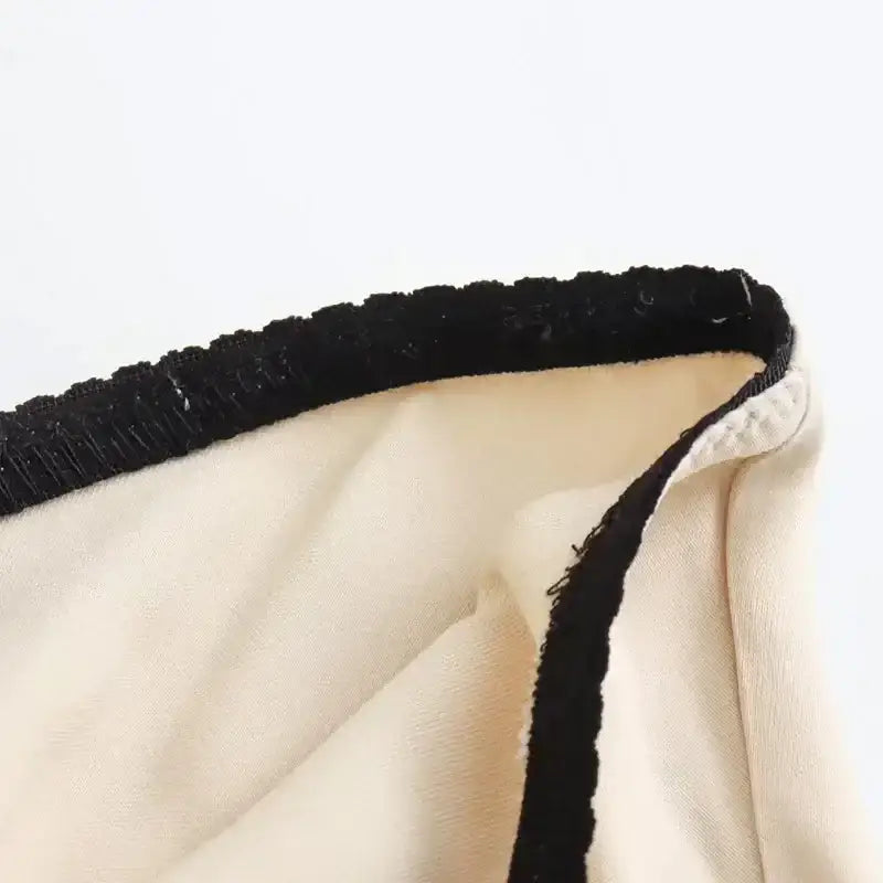 Close-up view of cream fabric with black trim detail on a ladies evening skirt from The Lady's Haven Boutique