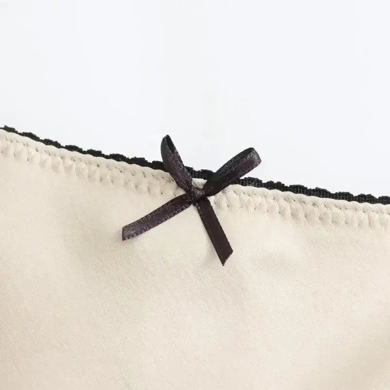 Close-up of black bow detail on cream fabric trim of ladies evening skirt from The Lady's Haven Boutique