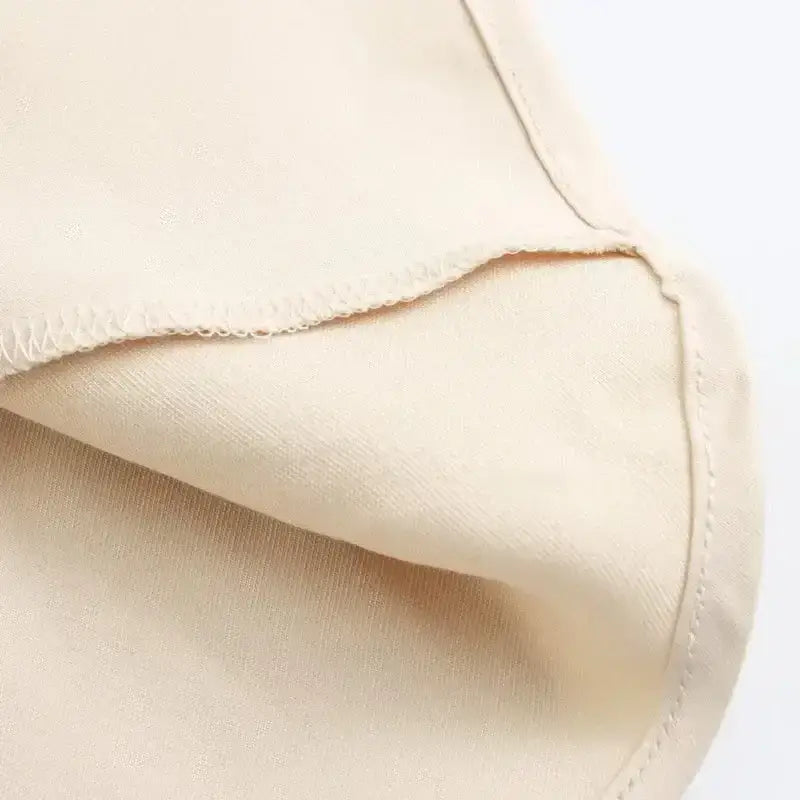 Close-up of cream fabric texture and stitching detail for ladies evening skirt