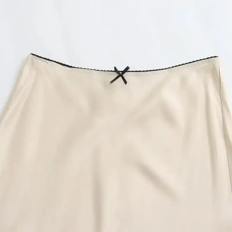 The Lady's Haven Boutique beige ladies evening skirt with black trim and decorative bow detail