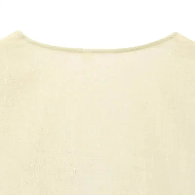 Close-up of the neckline detail on a cream-colored short sleeve blouse and pant set from The Lady's Haven Boutique