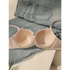 Embroidered floral underwear set with delicate lace details displayed on denim jeans