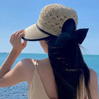 Stylish woman wearing fashionable straw hats for women with a bow detail by The Lady's Haven Boutique