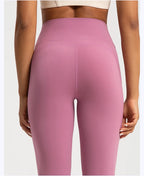 Back view of female high waist yoga leggings in soft pink color for stylish comfort during workouts