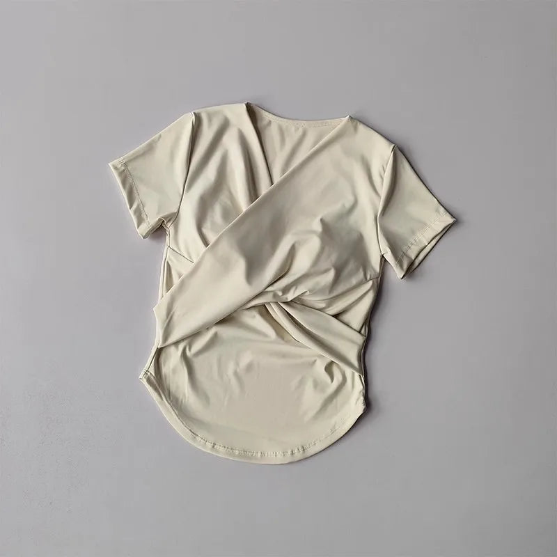 Light beige female quick dry sports top with built in cup and stylish back design