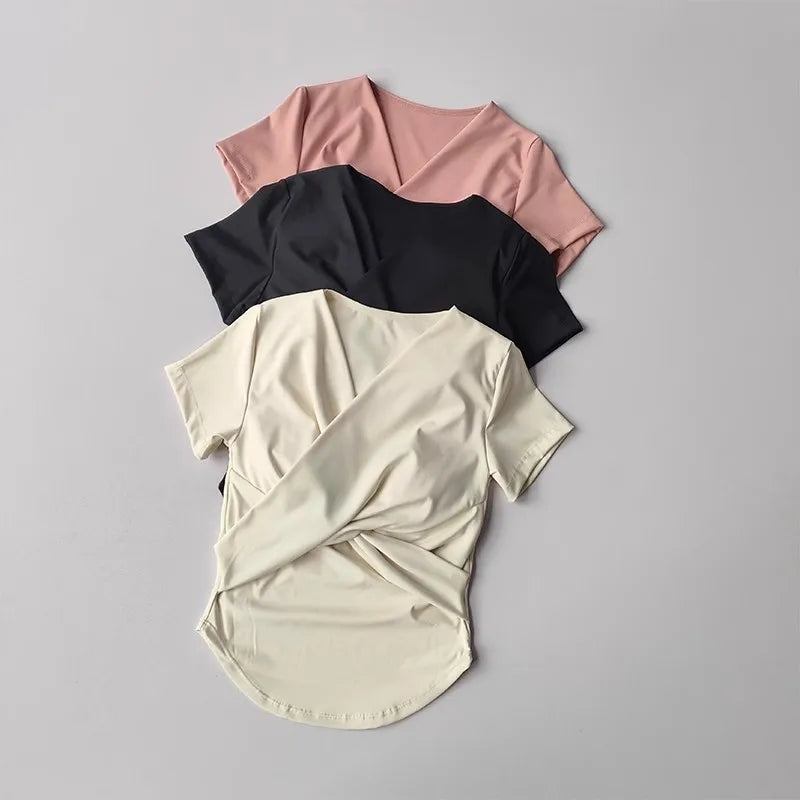 Set of three female quick dry sports tops with built in cup in pink, black, and cream colors