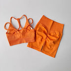 Bright orange fitness bra and shorts set featuring a stylish crisscross design and flattering fit