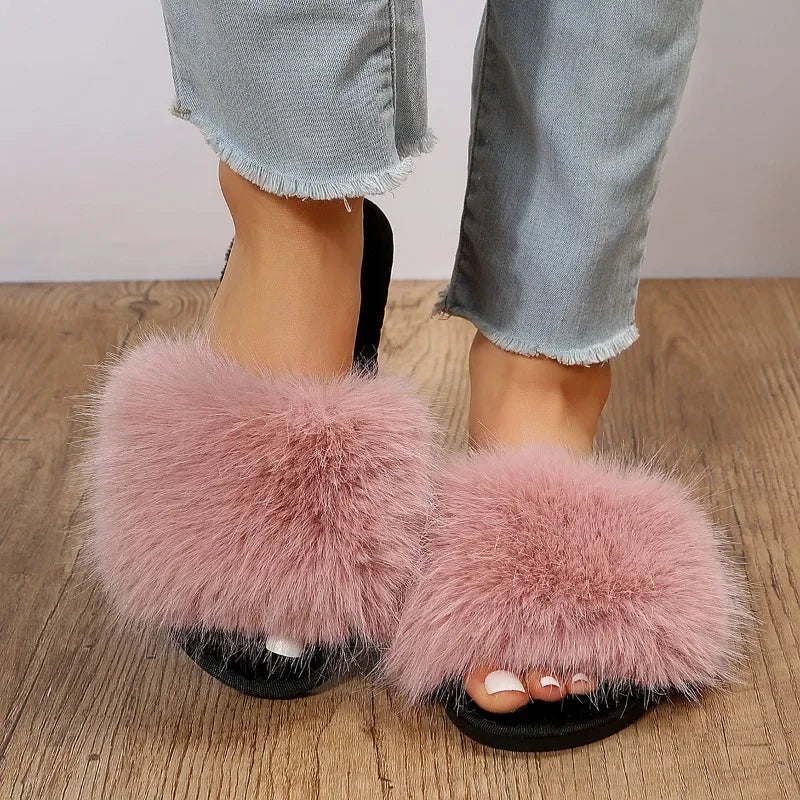 The Lady's Haven Boutique pink fuzzy flat slide slippers with soft plush straps on wooden floor